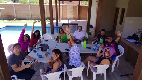 Friends gathered around a table in the covered outdoor area