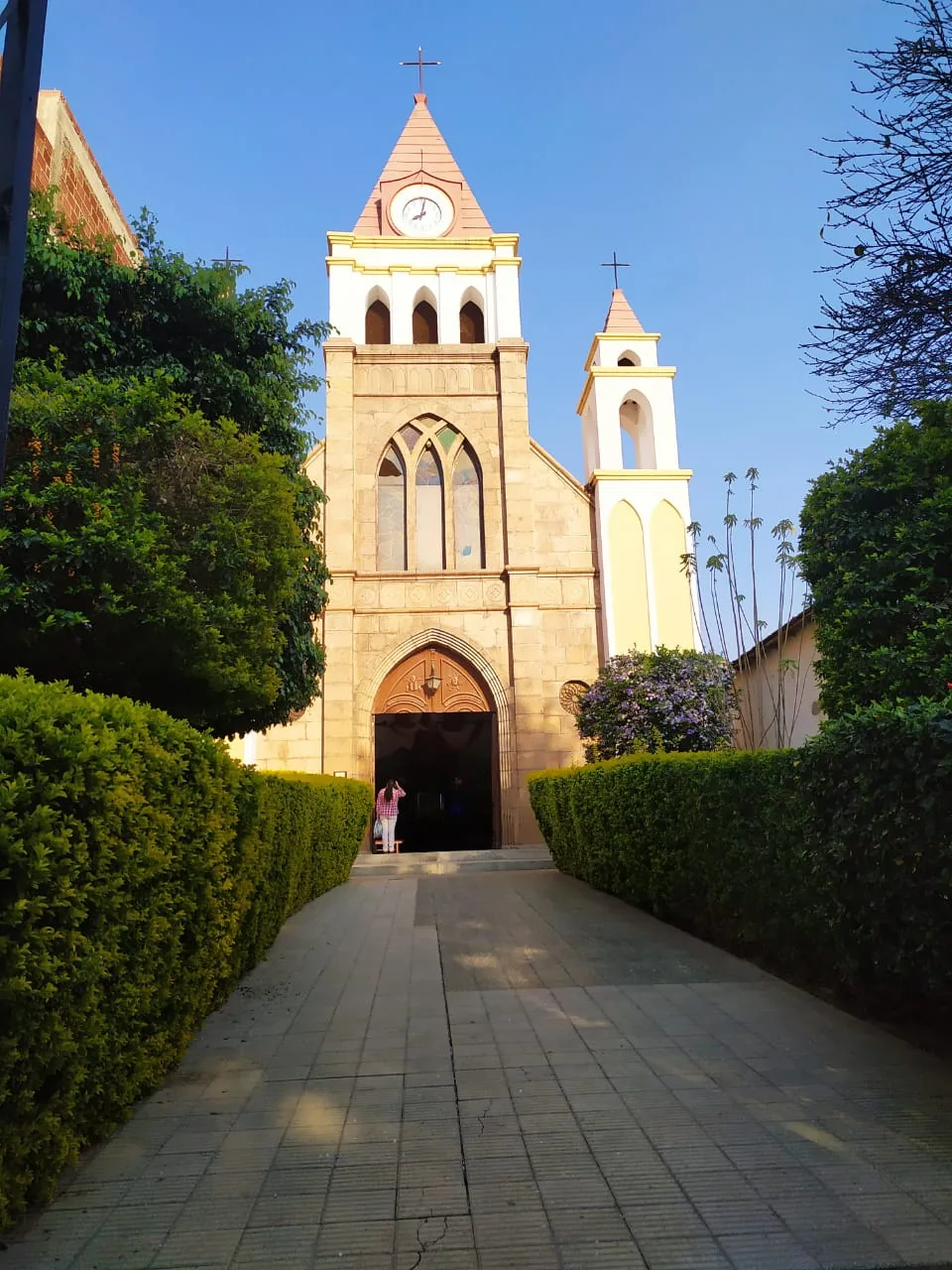 Fachada completa de una iglesia de Capinota vista desde el sendero del jardín