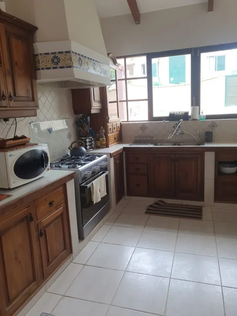 Cocina con muebles de madera y ventana hacia el exterior