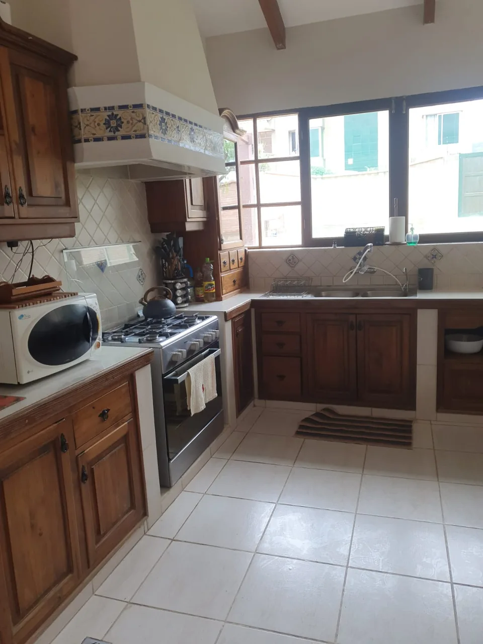 Cocina con muebles de madera y ventana hacia el exterior
