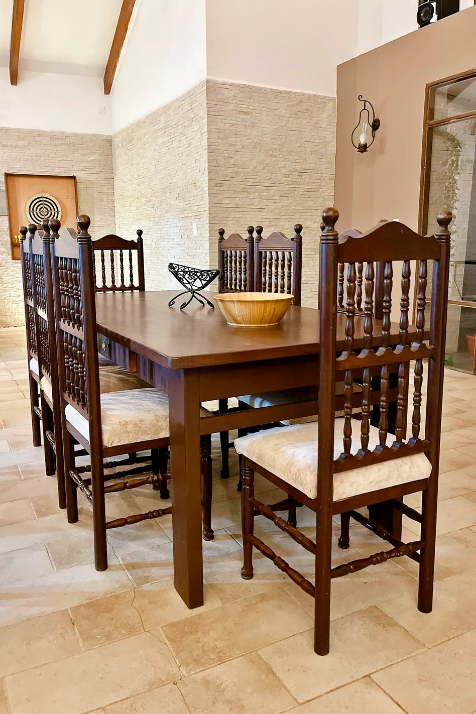 Comedor de madera con el juego de dardos al fondo