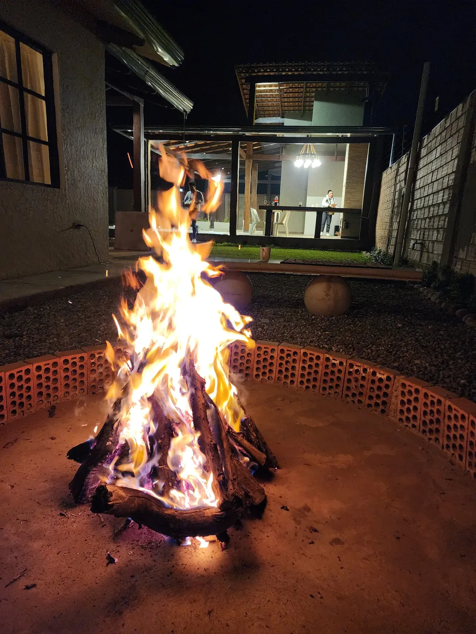 Fogata encendida con el parrillero al fondo