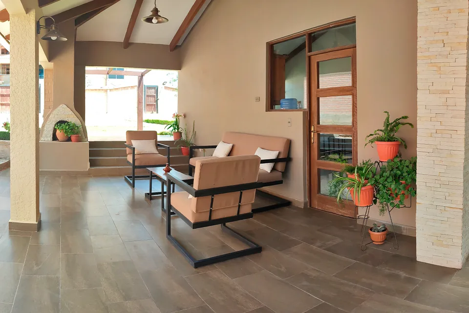 Galería techada con sillones junto al jardín