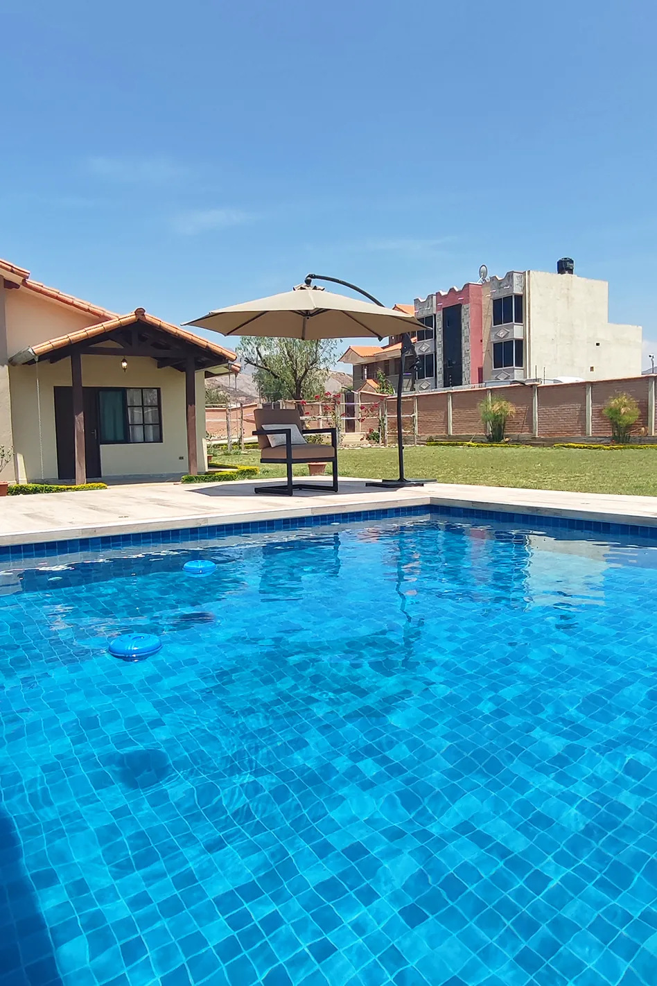 Vista desde la piscina hacia la casa y las montañas